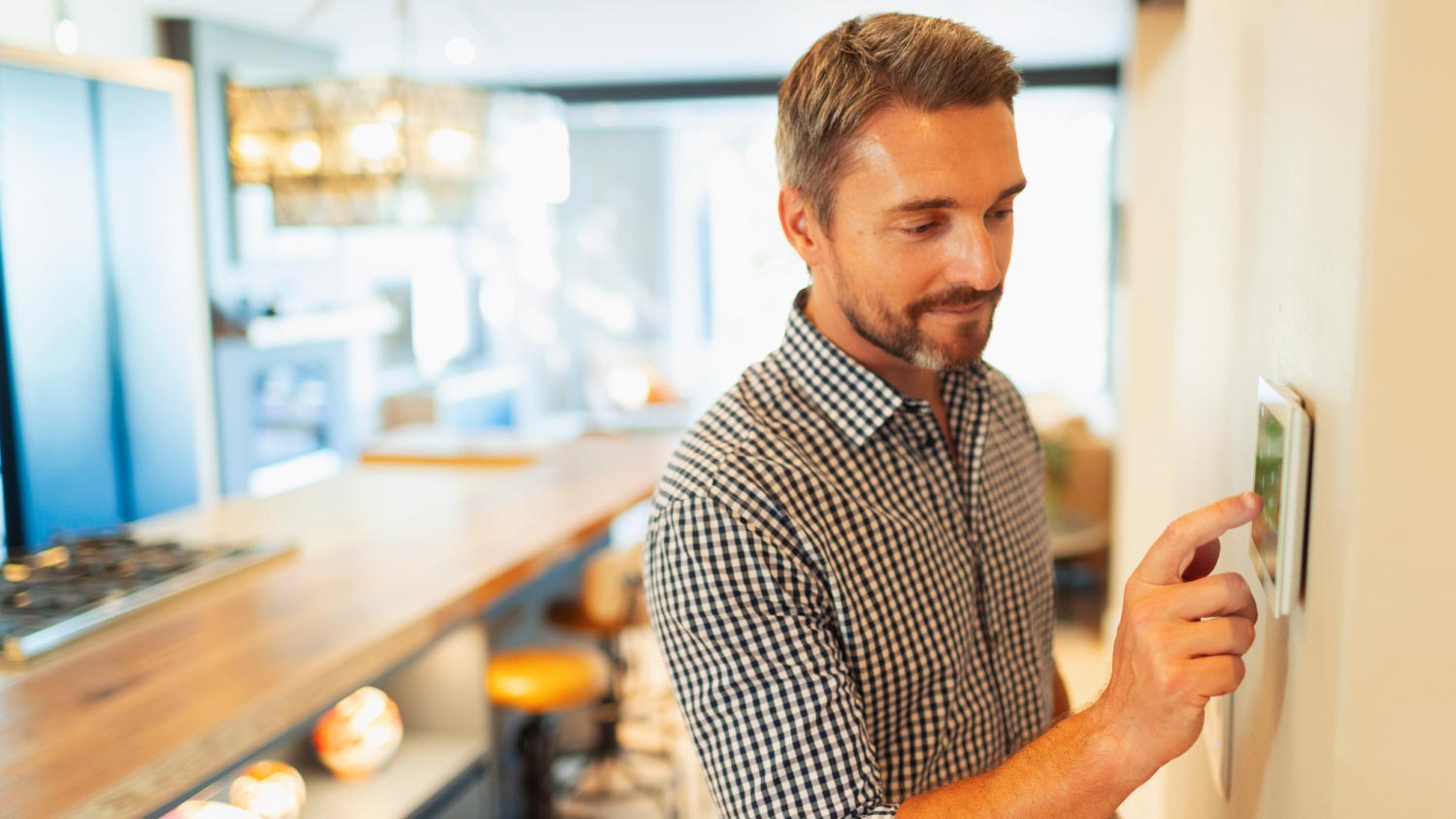 Man adjusting digital home automation thermostat