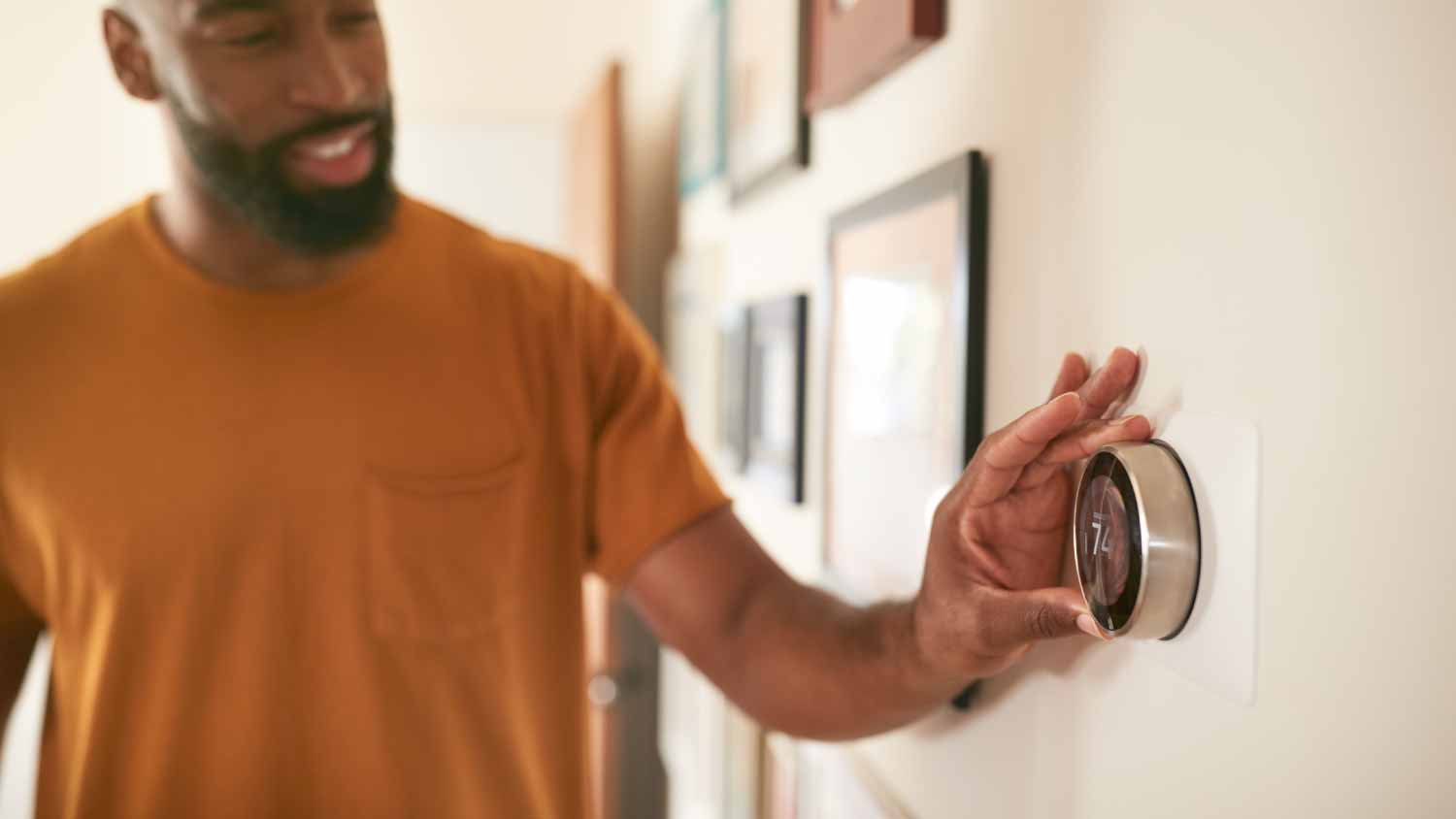 Man adjusting digital thermostat 