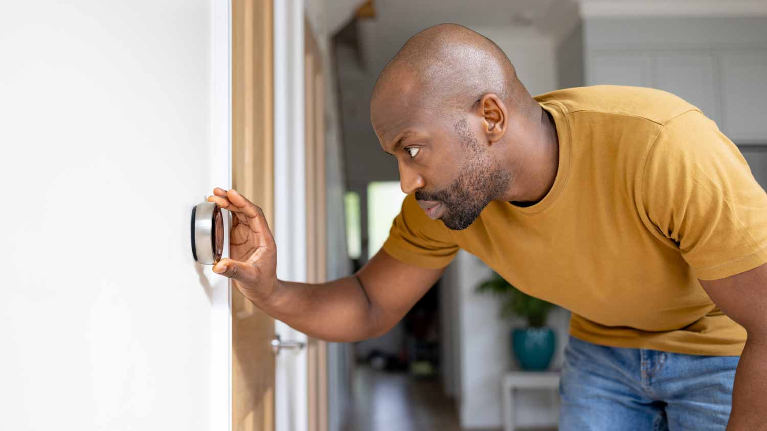 Man adjusting the temperature on the thermostat