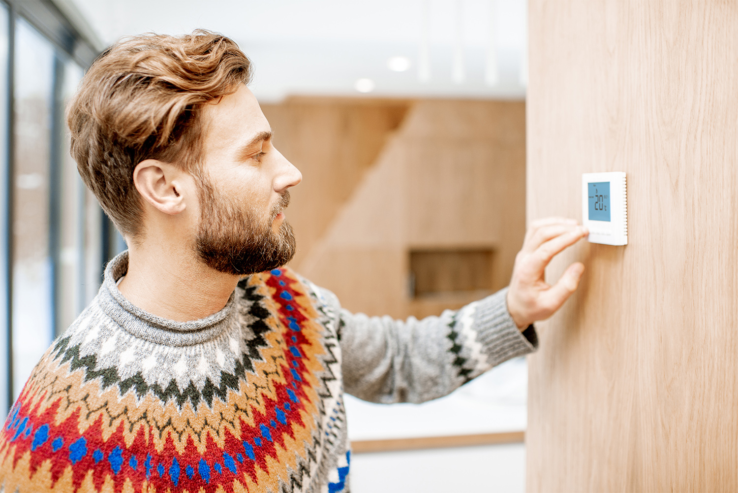 Man adjusting the temperature on the thermostat