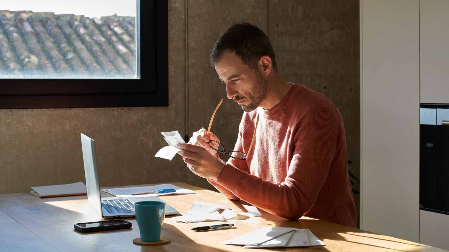 Man analyzing financial bills at home