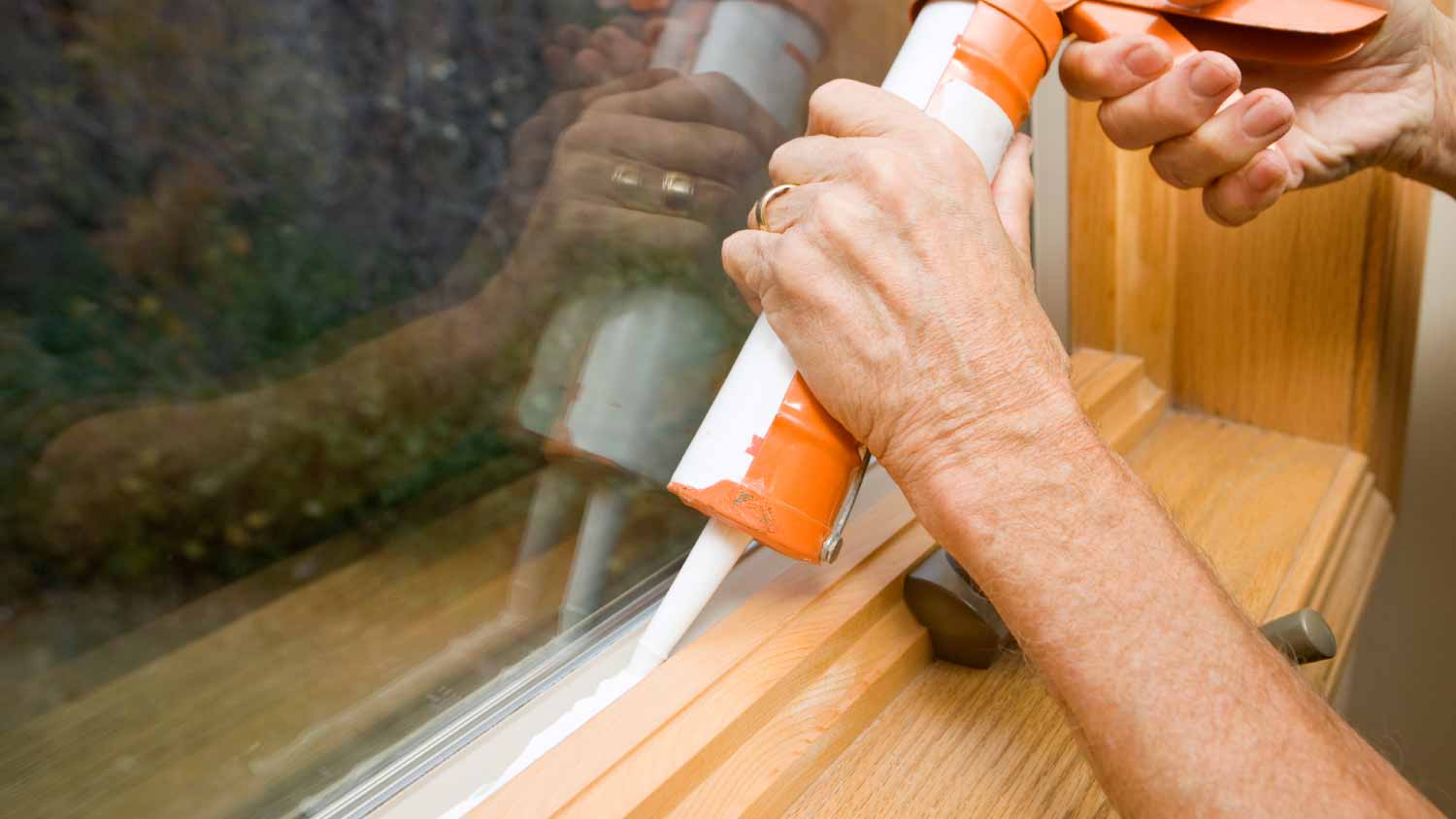 Man applying weather seal caulk