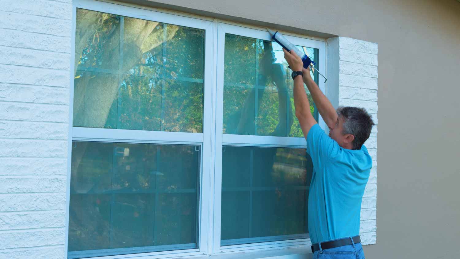 Man caulking window