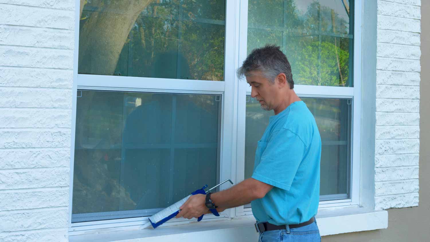 Man caulking window