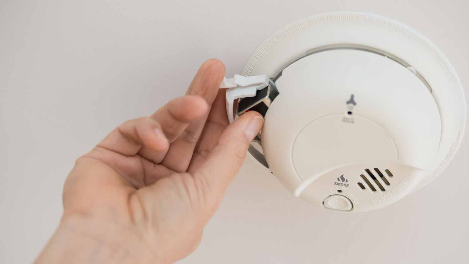 Man changing battery in smoke alarm