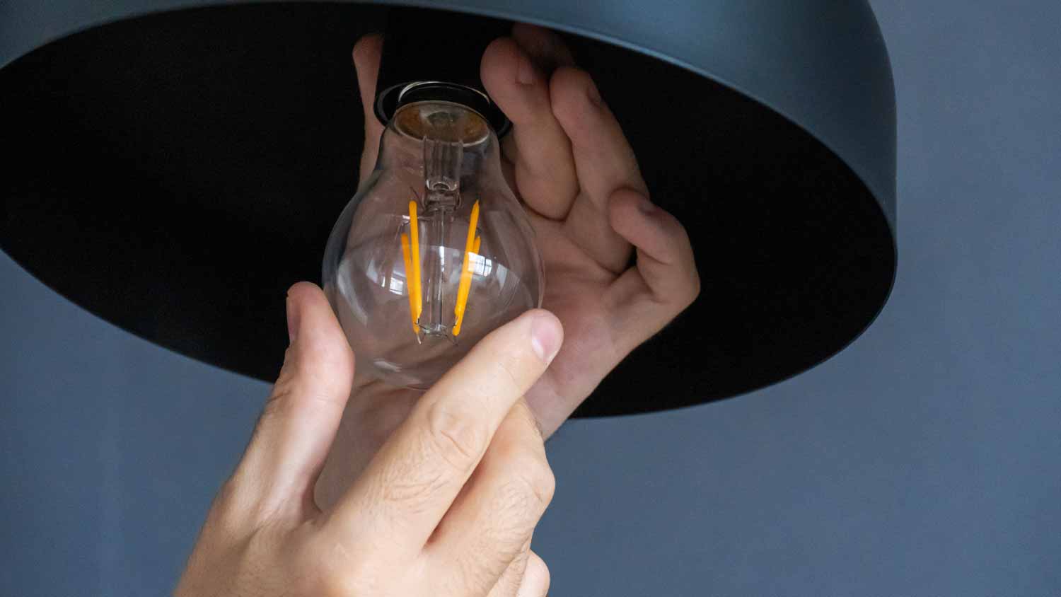 Man changing bulb in house