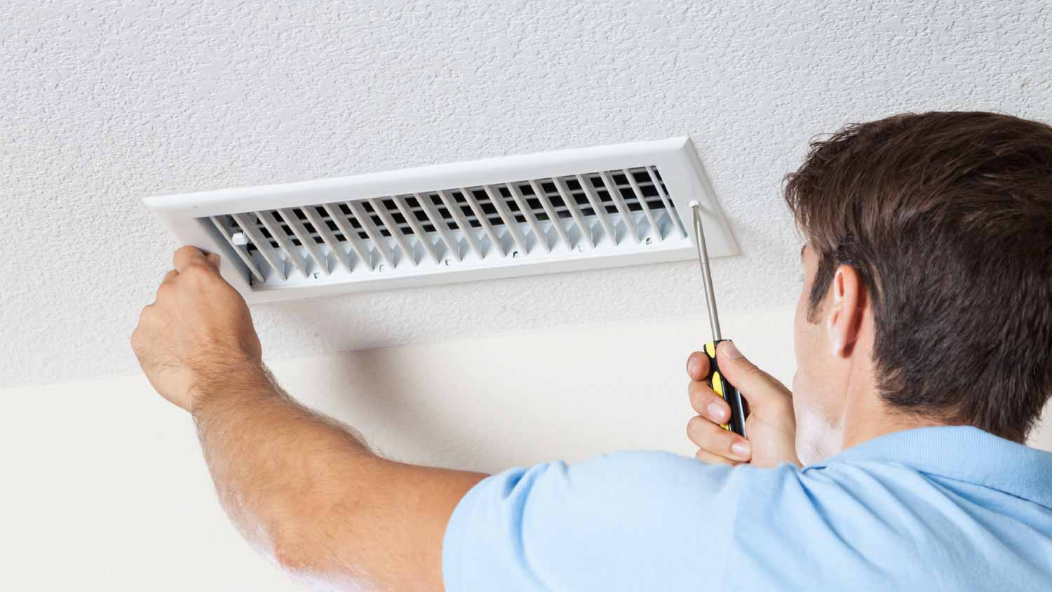 Man cleaning air duct