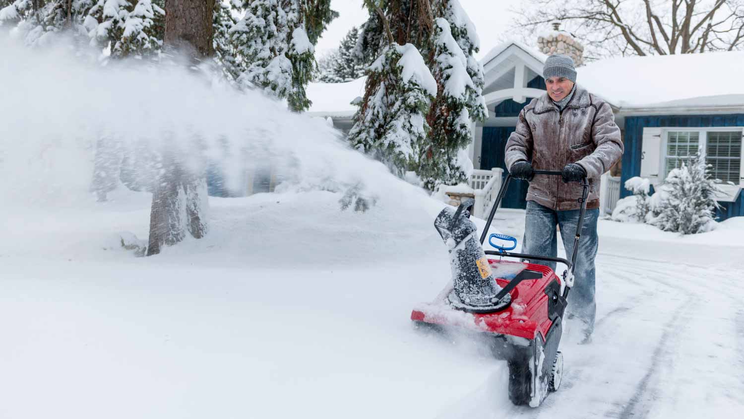 Man clearing driveway with snow blower