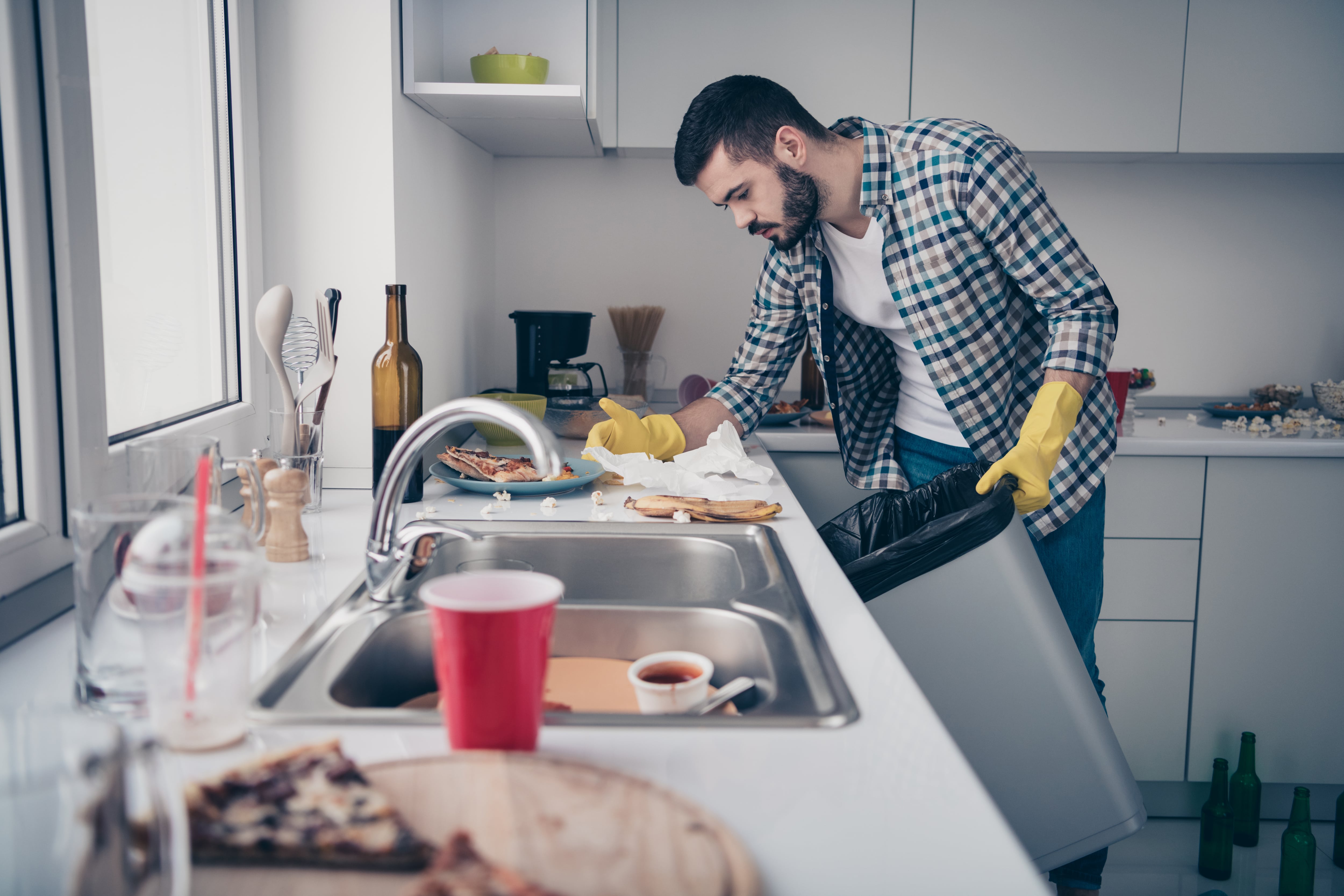 Man cleaning messy kitchen