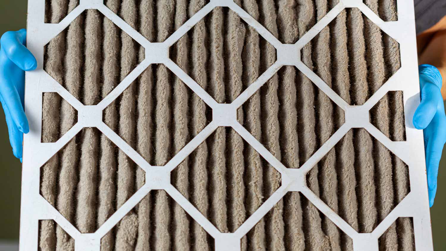 Man holding dirty air conditioner furnace filter 