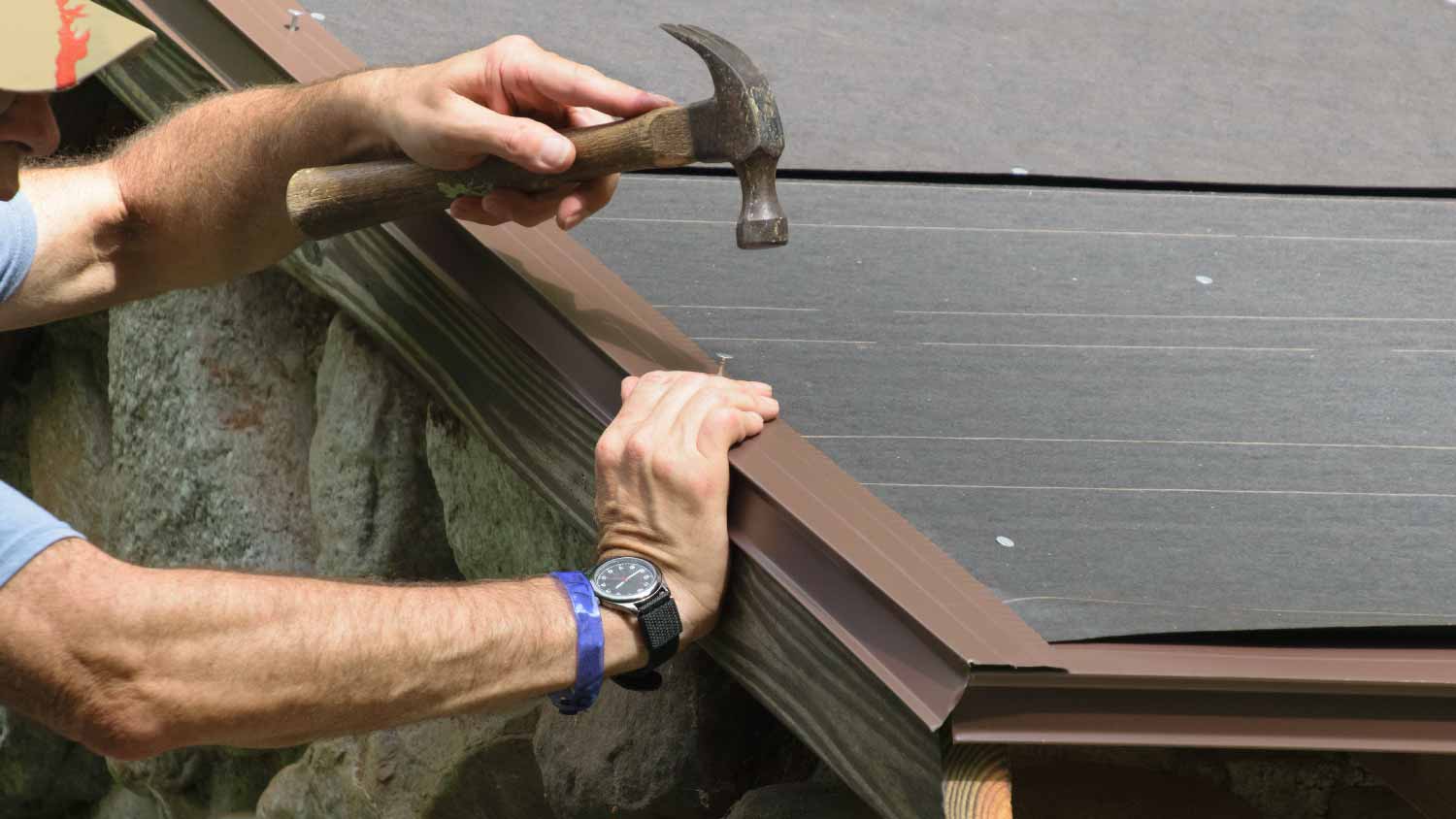 Man installing a drip edge over roof