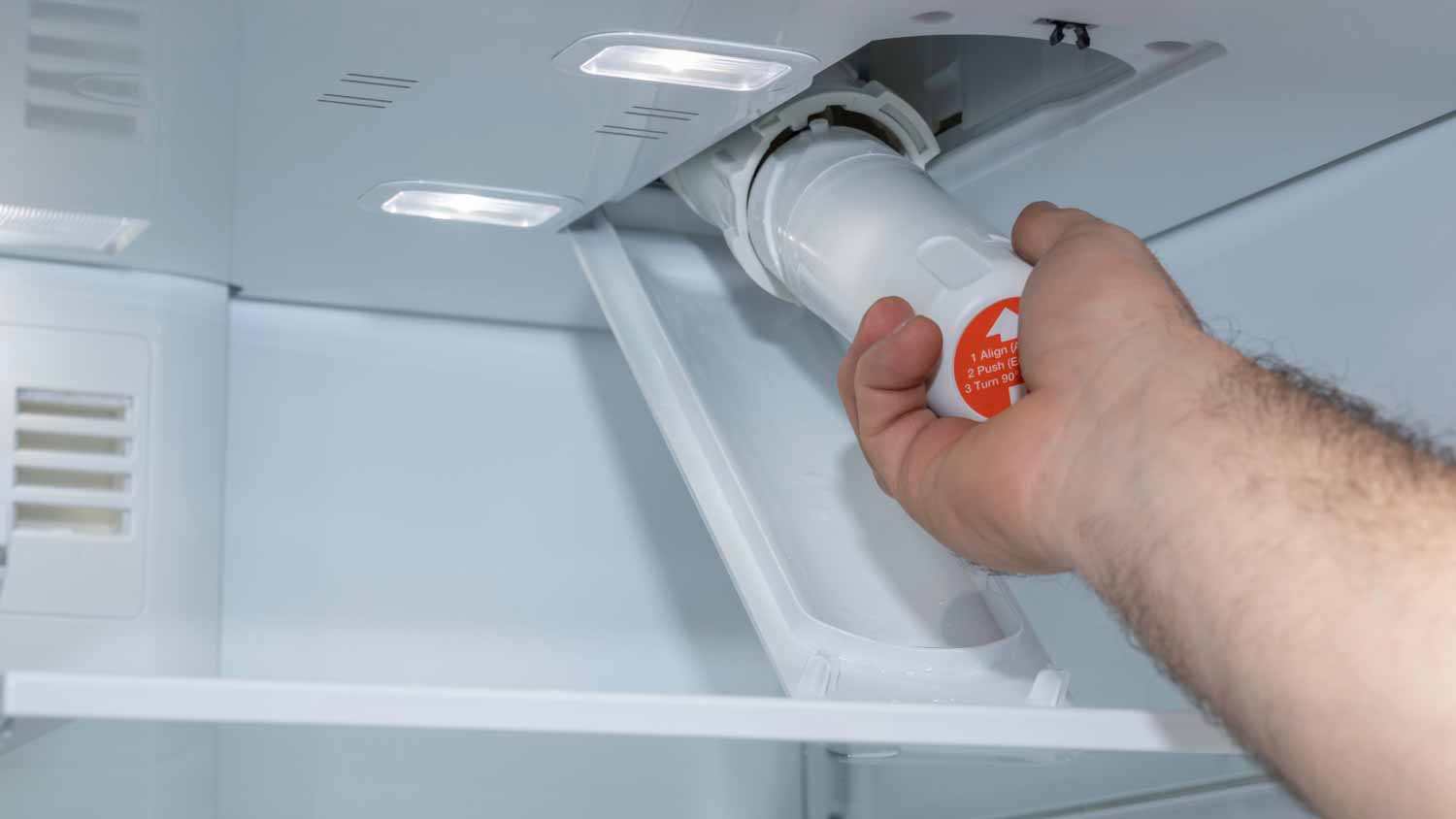 Man installing a fridge filter