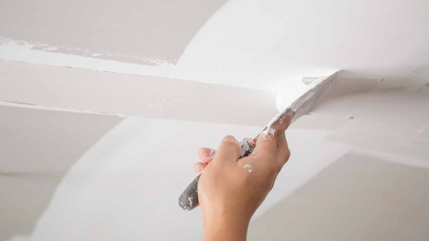 Man installing plasterboard