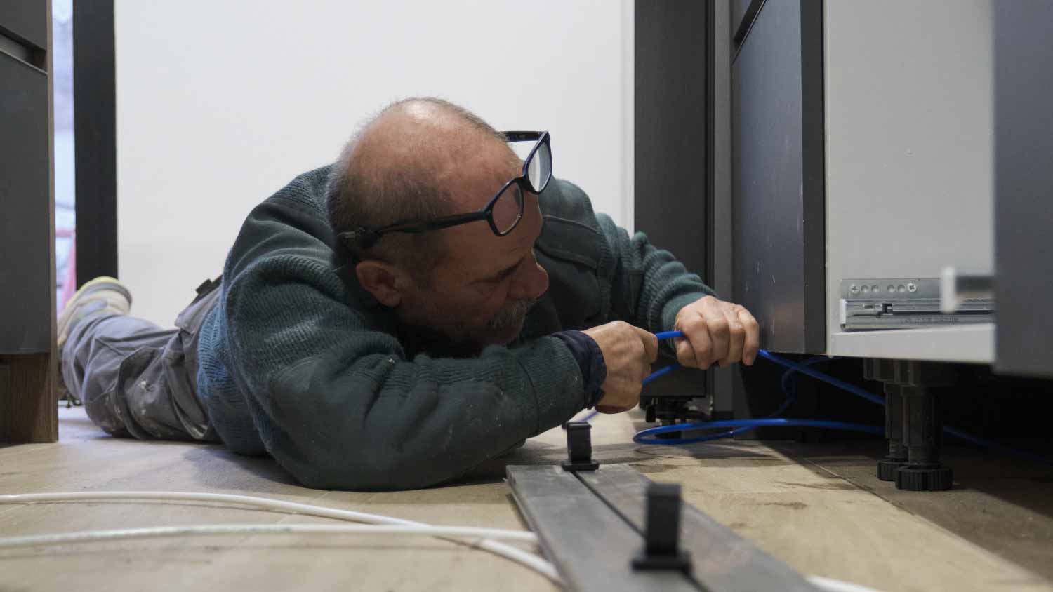 Man installing water filter to a refrigerator