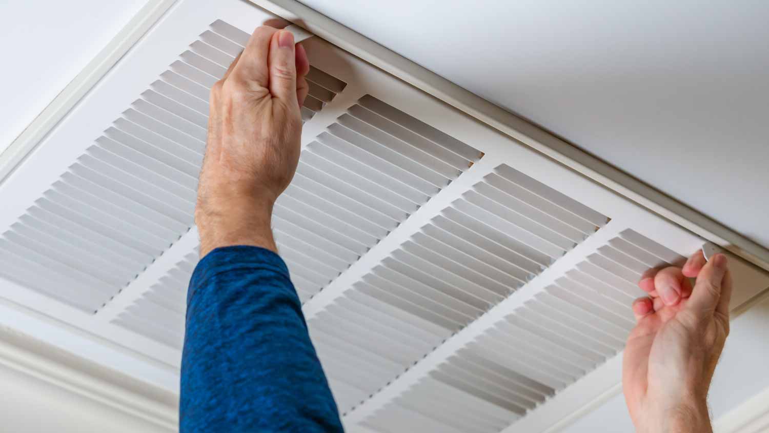 Man opening ceiling air vent