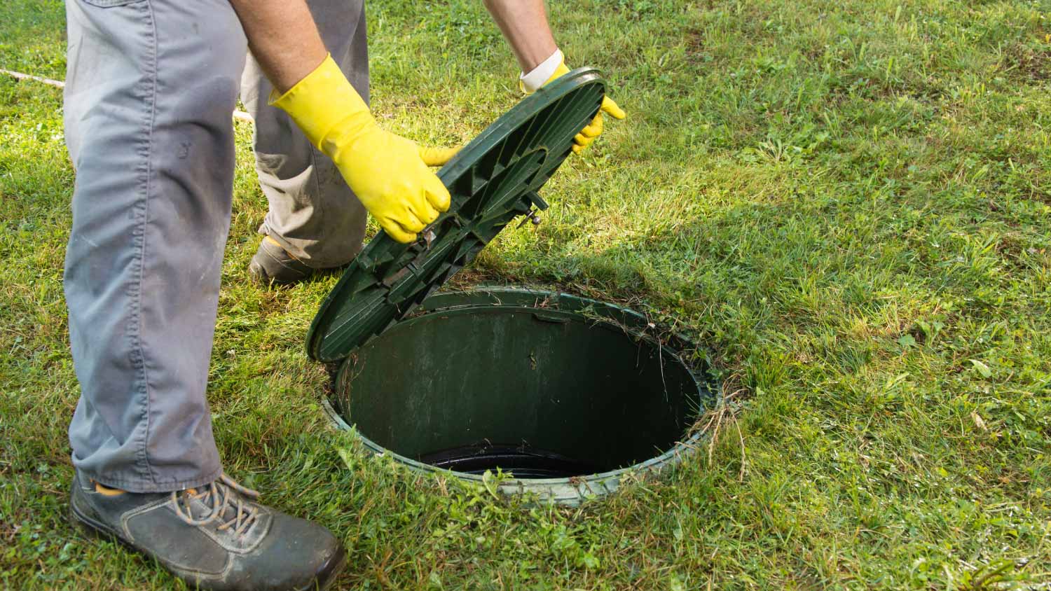 Man opening septic tank lid