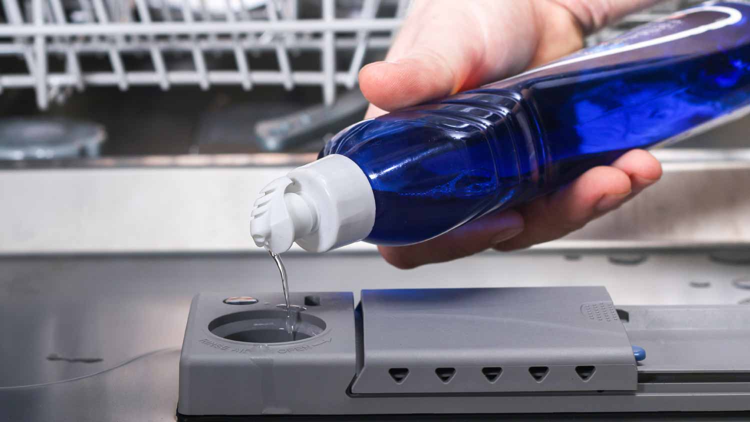 Man pouring rinse aid into dishwasher