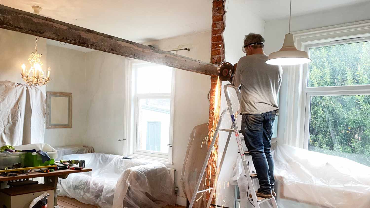 Worker removing metal beam from wall