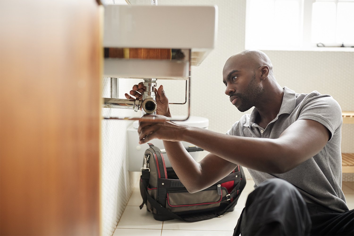 Man repairing leaky sink pipes