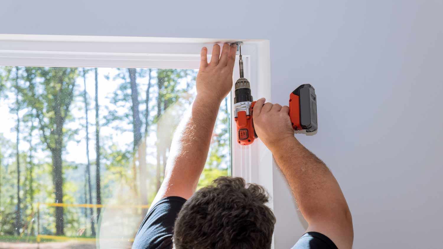 Man screwing the fastenings on the windows