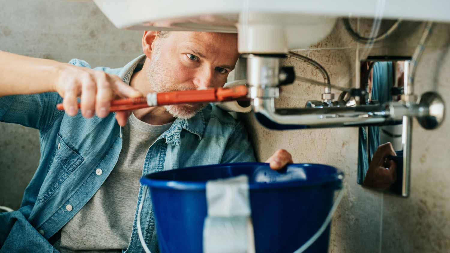 Man trying to fix a leak in a sink