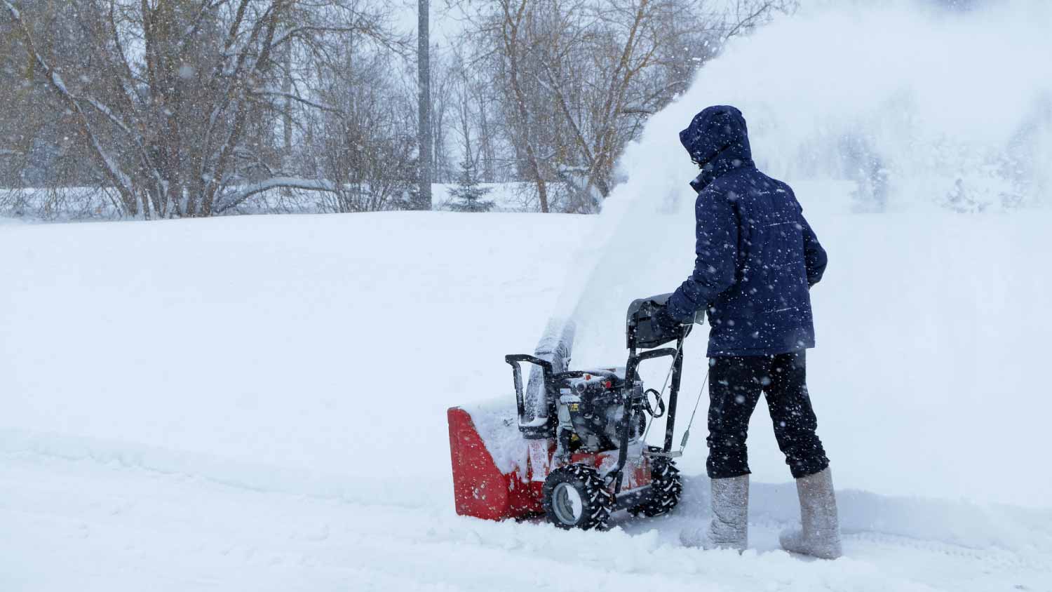 Man using snow blower to clear driveway