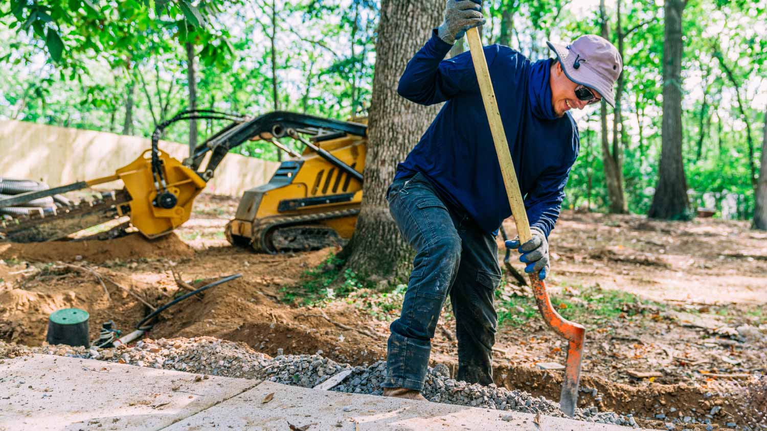 Man using a trenching shovel to dig a trench 