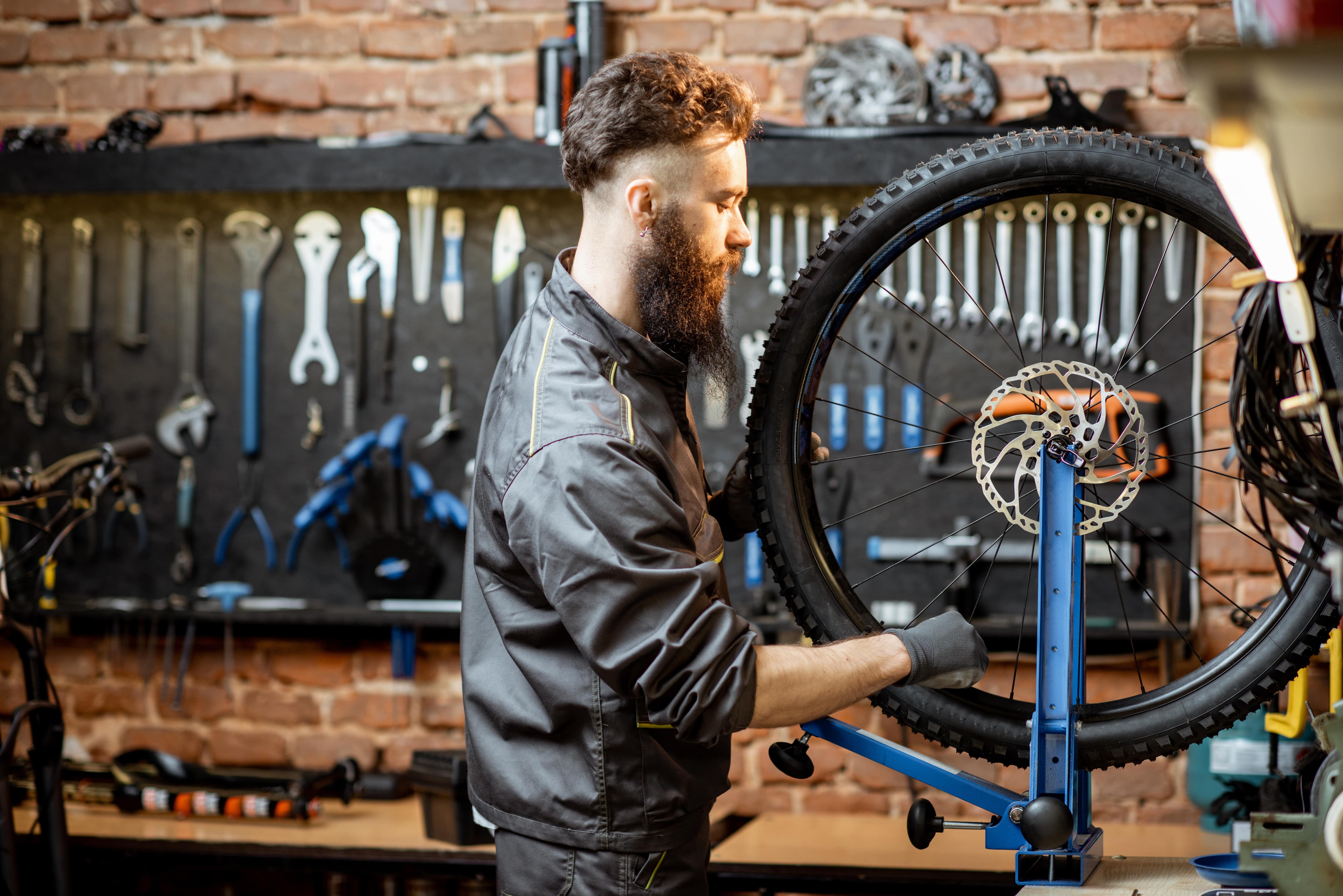 A man working on a bicycle in a well-lit garage with task lighting