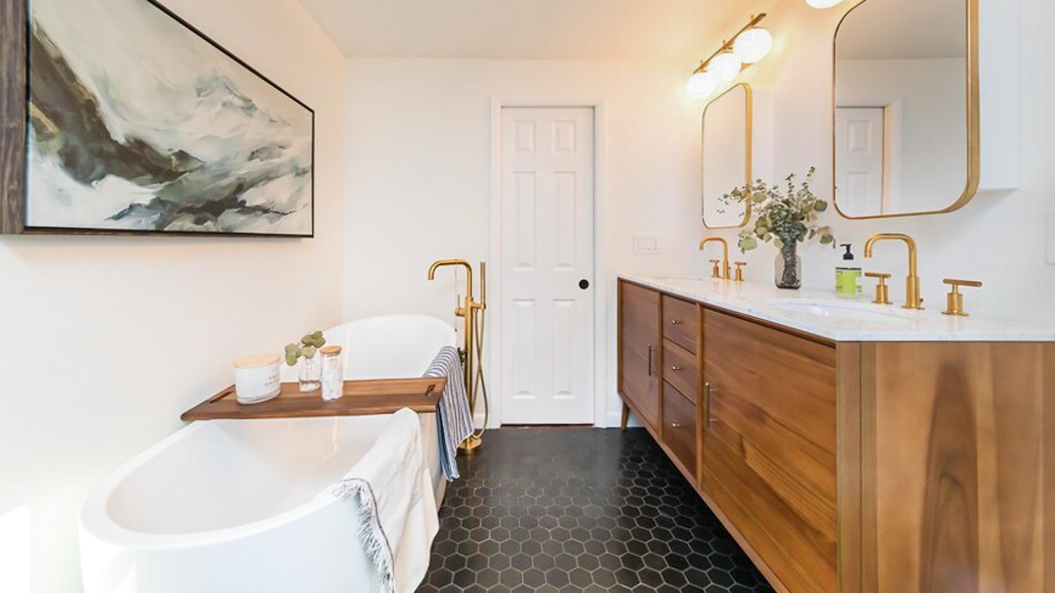 white bathroom with black tile floor and wood cabinets