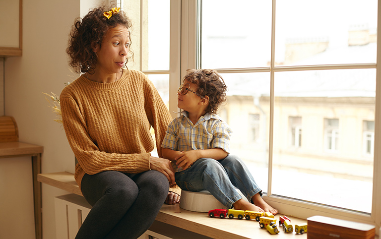 A mother and son play in a window.
