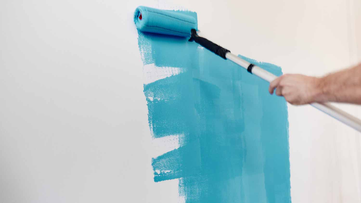 Painter painting the wall in blue