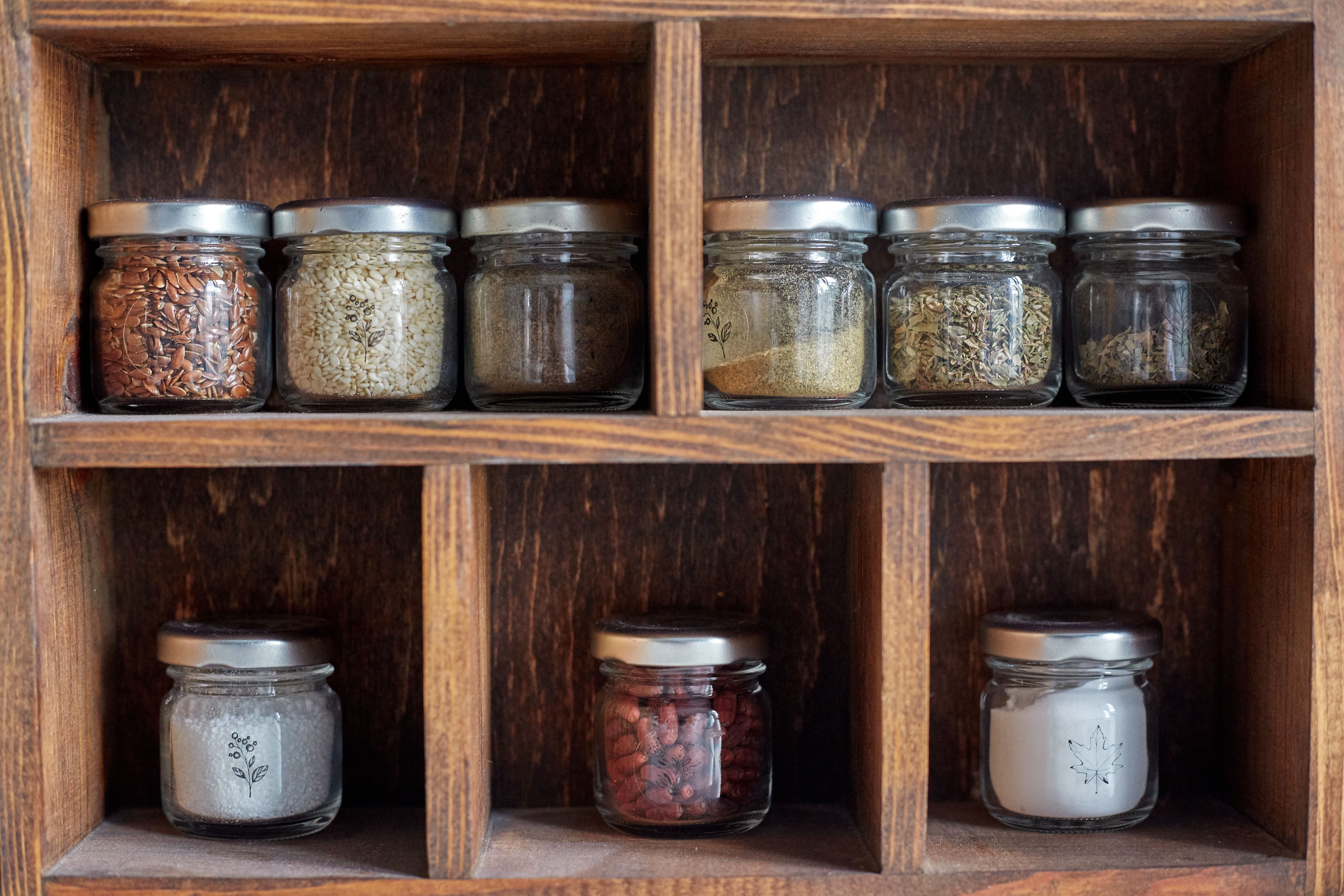 Spices in containers on a wooden shelf