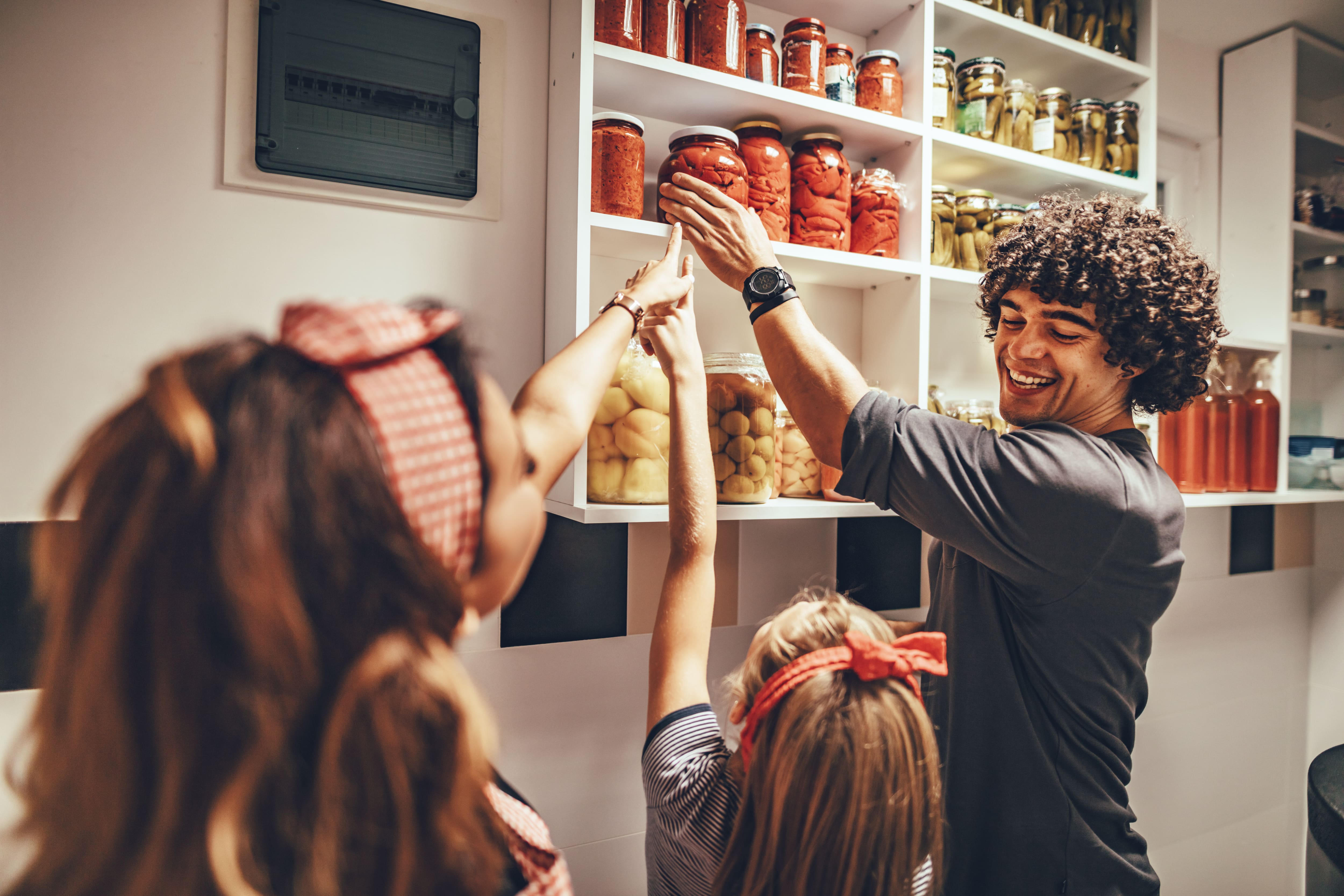 Man reaching for jar in kitchen pantry