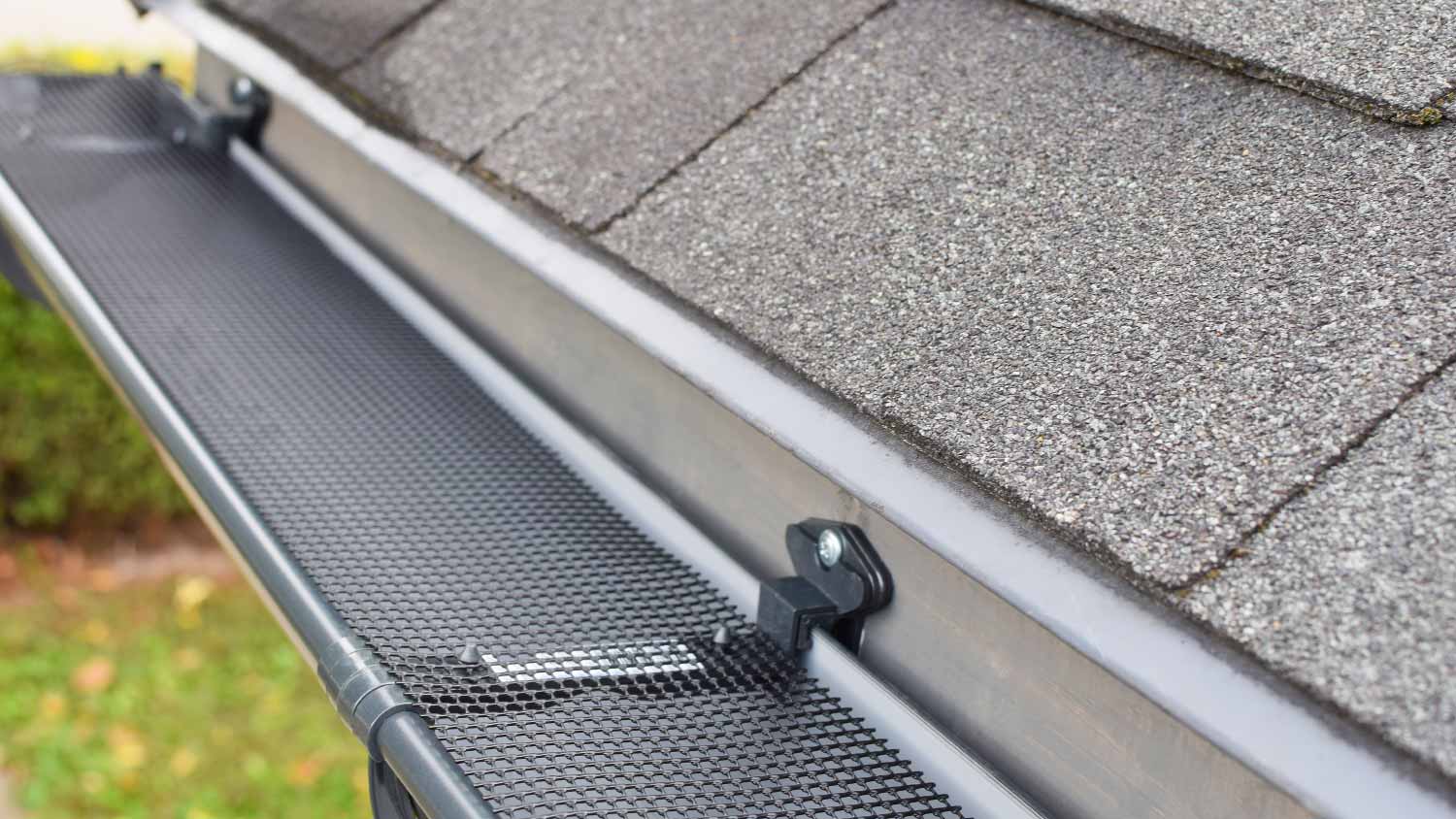 Plastic guard over new dark gray plastic rain gutter