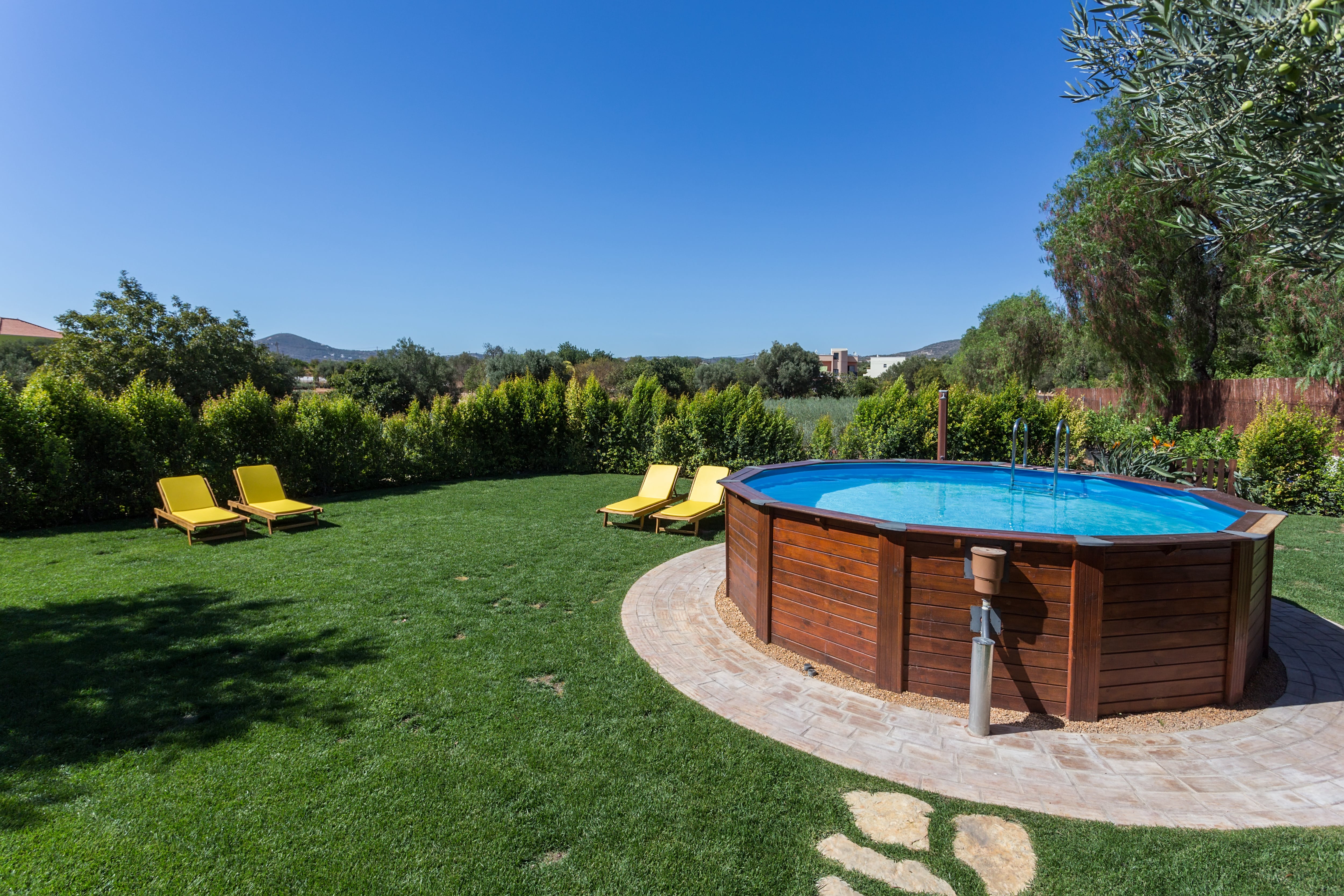 Above ground pool with wooden casing on a cement slab