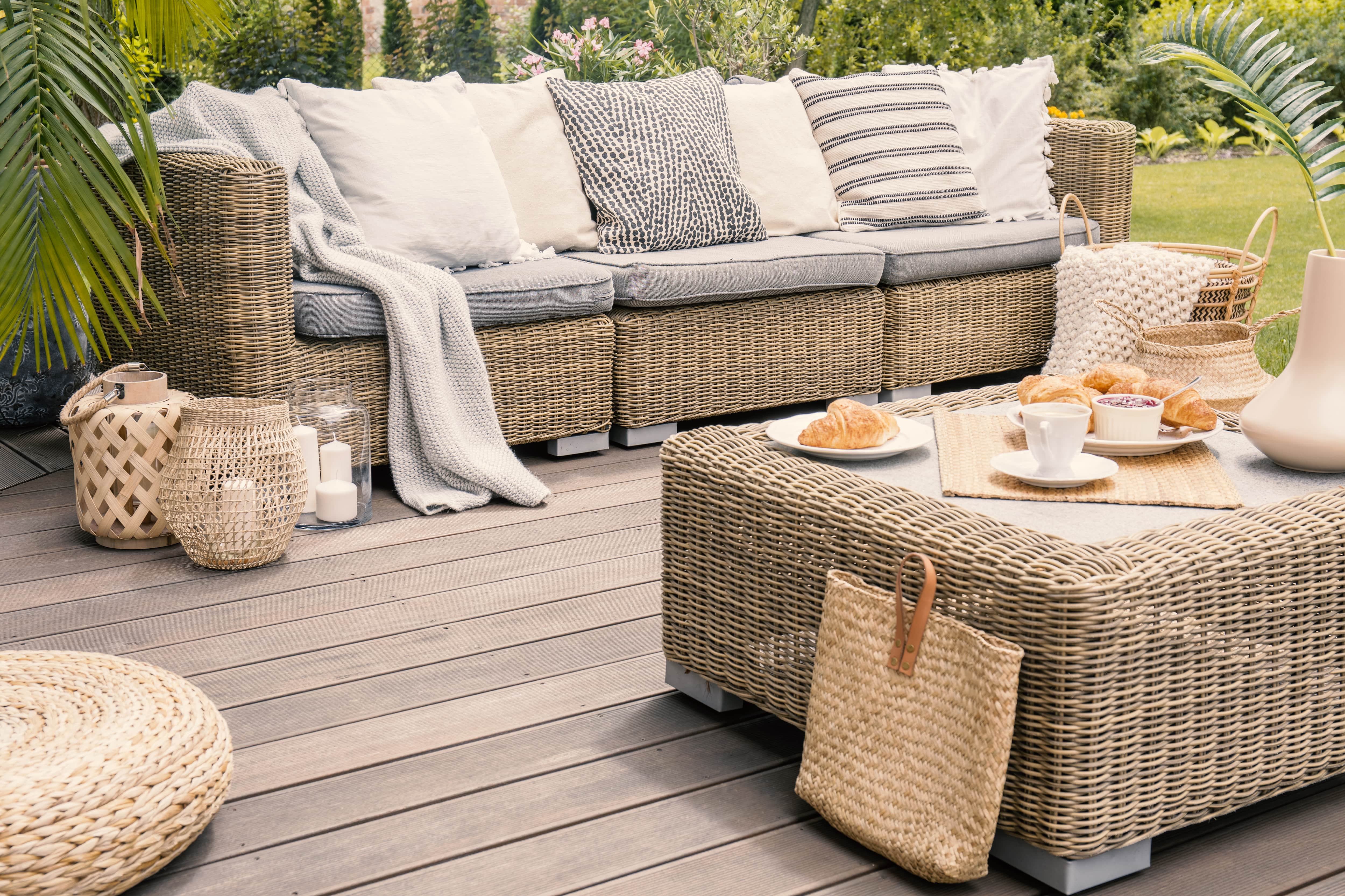 A home lounge on a wooden deck including wicker patio furniture