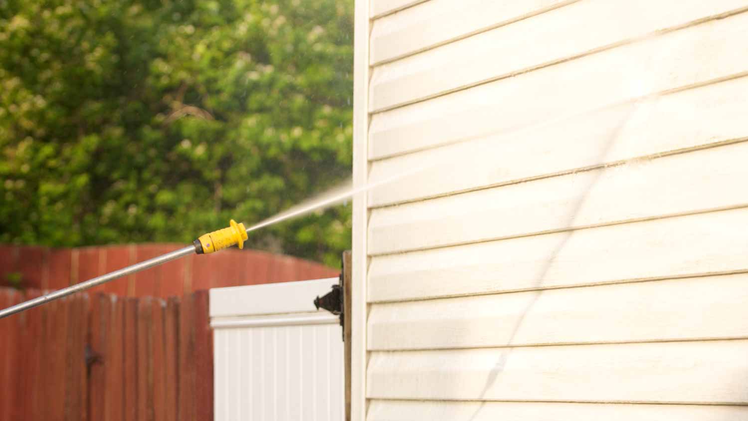 Pressure washer being used on siding