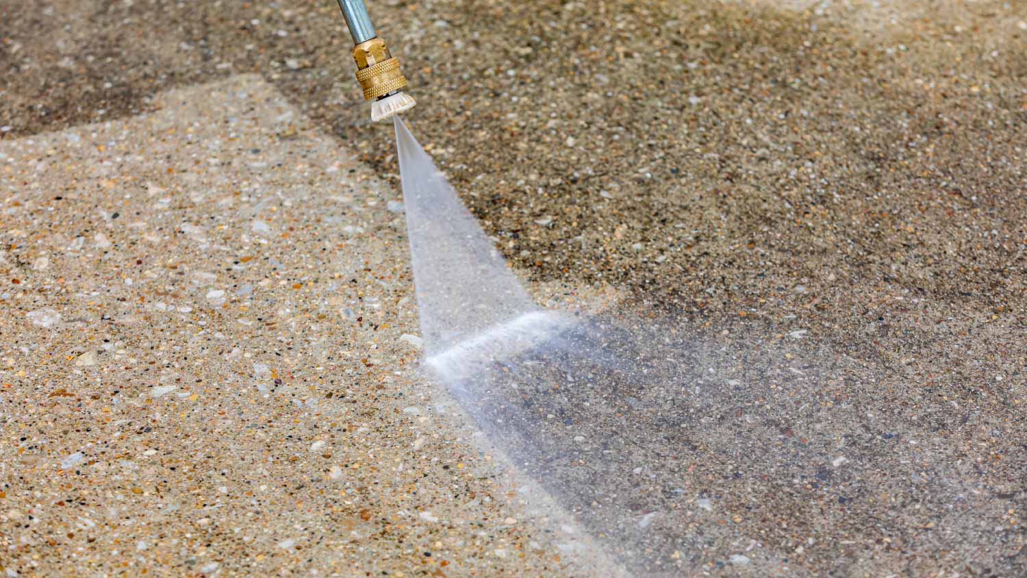 Pressure washing dirty concrete driveway