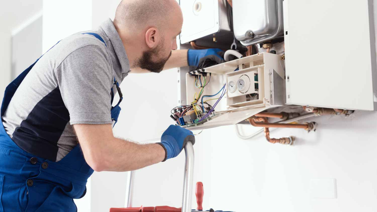 Professional engineer servicing a boiler at home