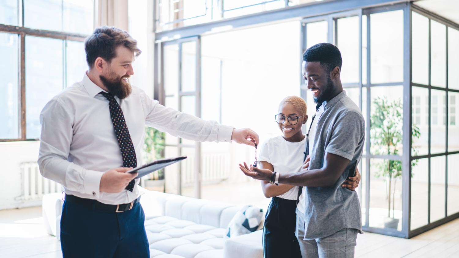 Real estate agent giving keys to a couple