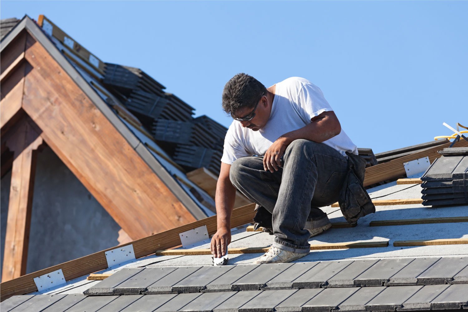 A roofer installing a new slate roof