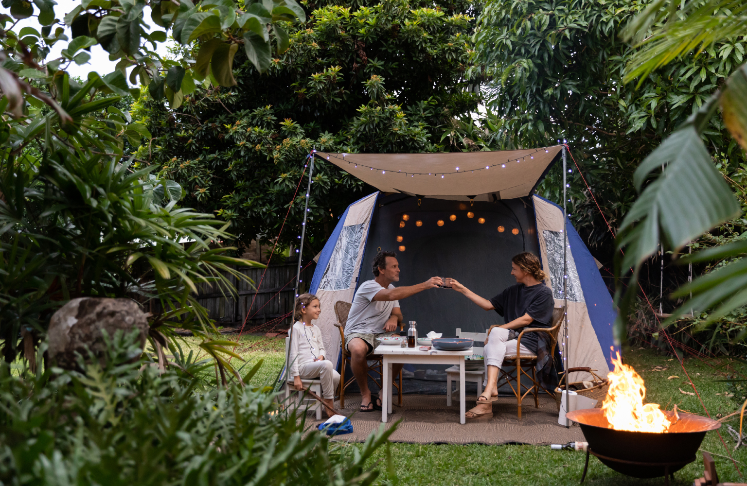 family in backyard with camping tent 