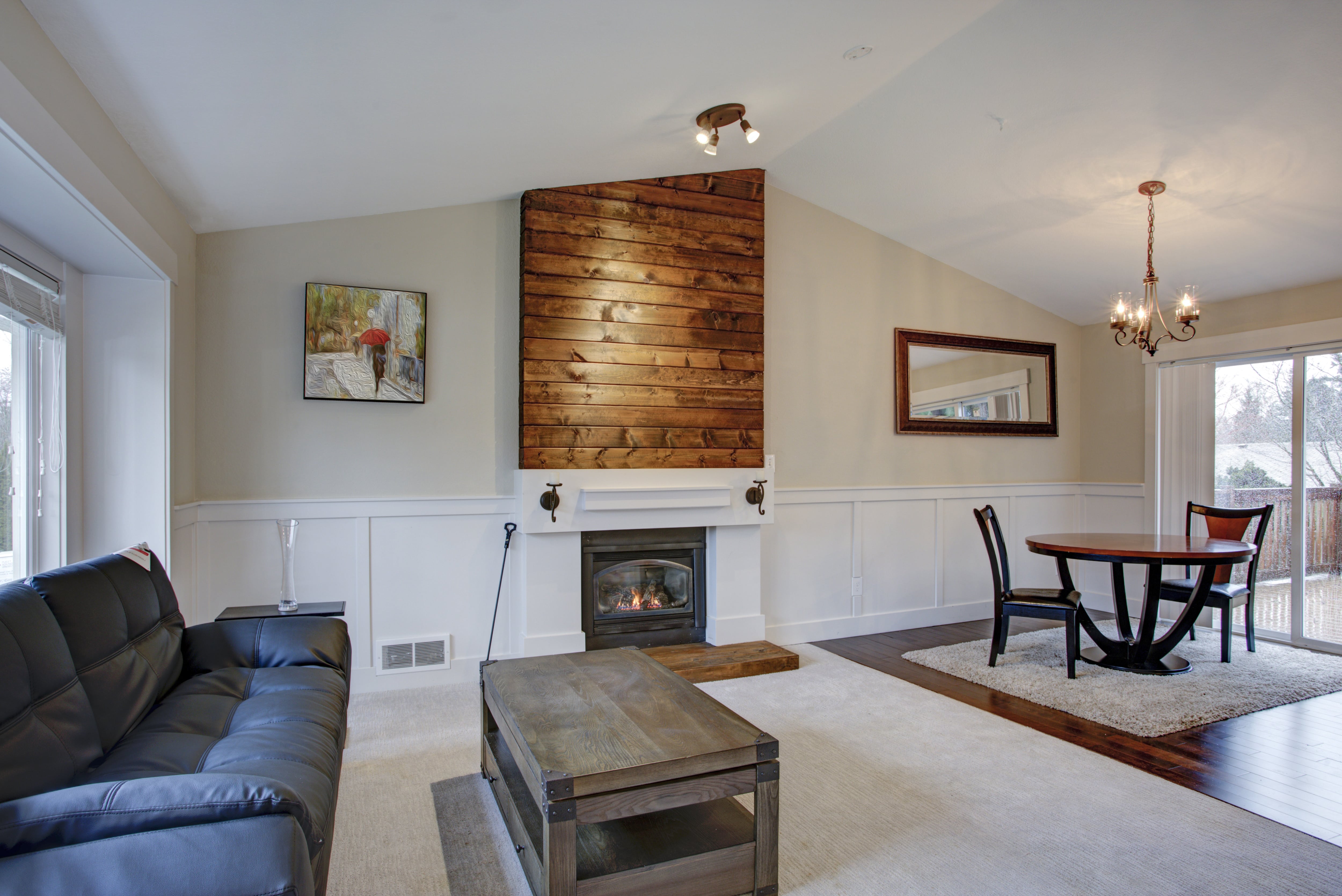 Vaulted living room with natural wood shiplap fireplace