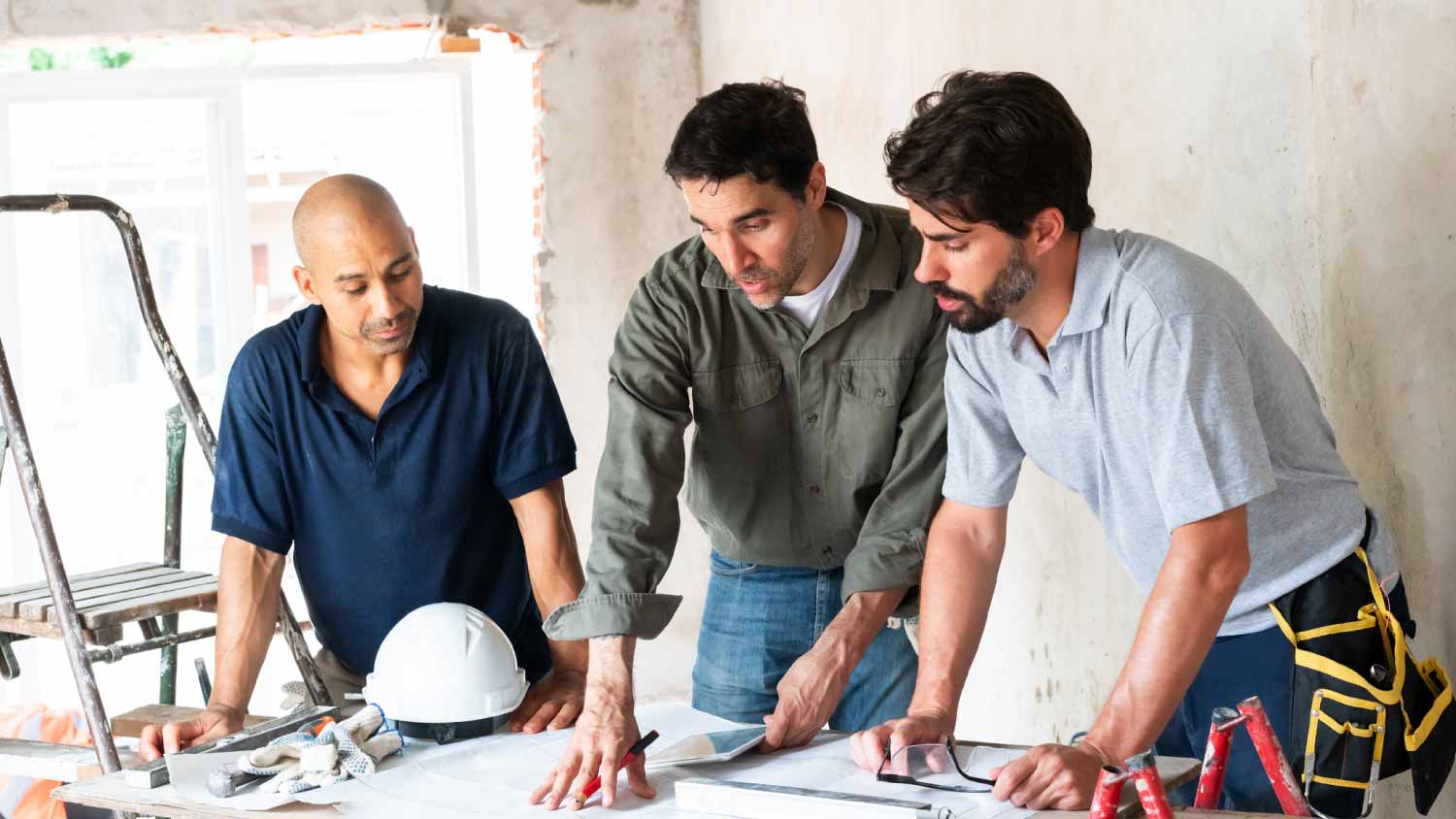 Three construction workers planning