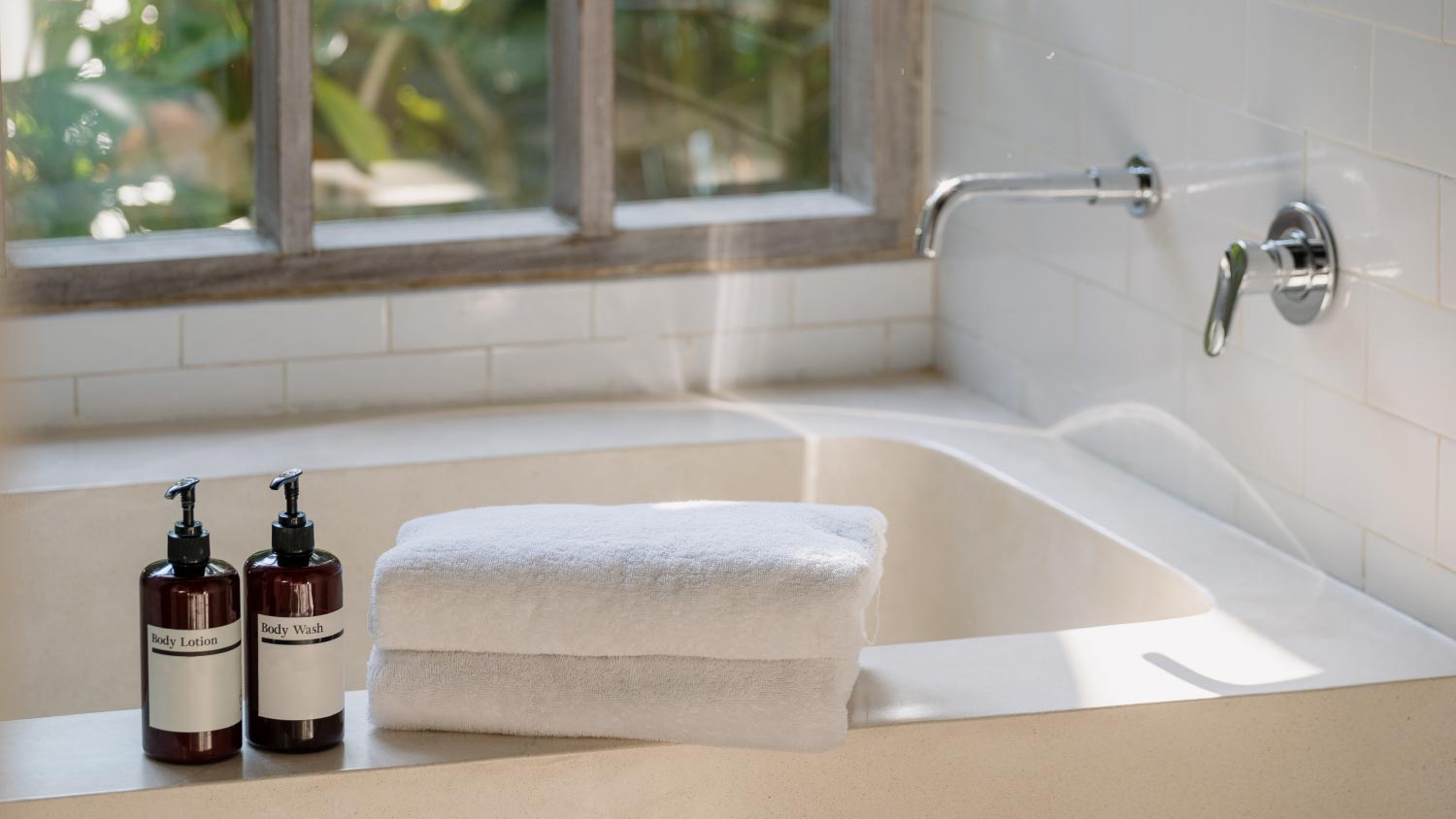 Two bottle on top of ceramic bathtub