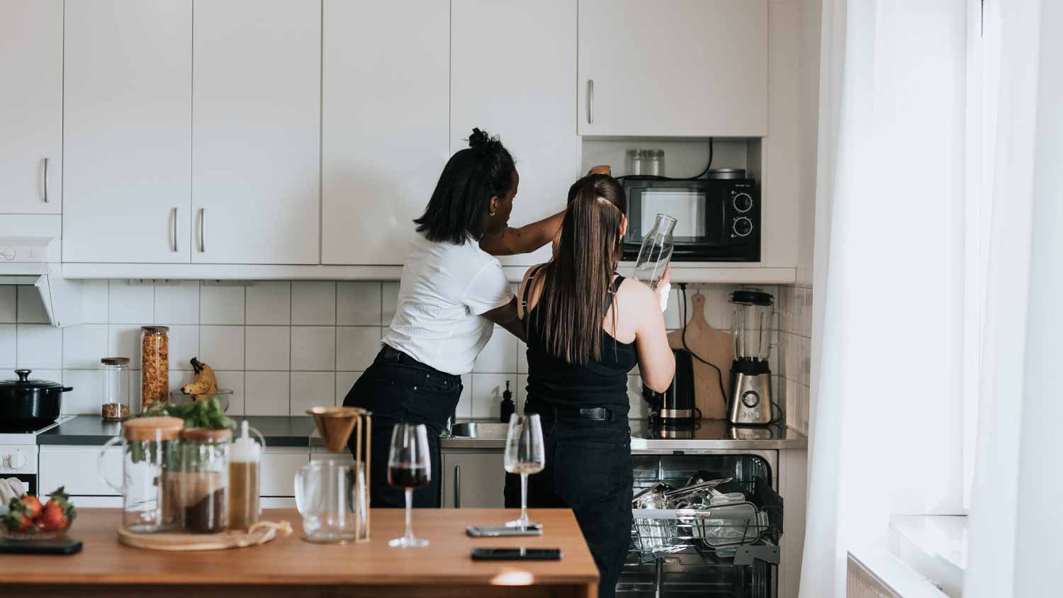 Two women checking the microwave