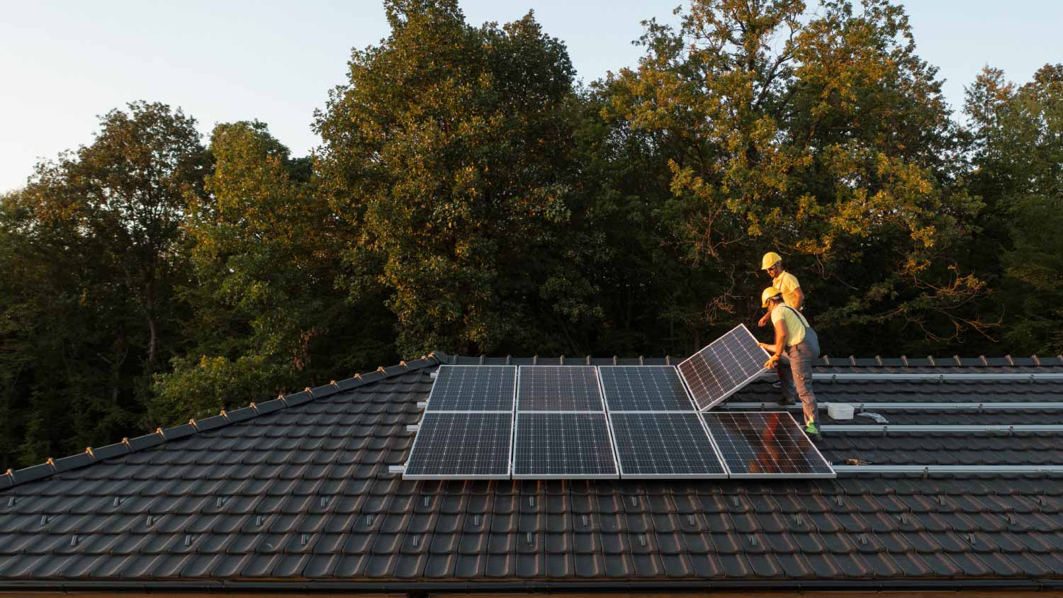 Two workers installing solar panels