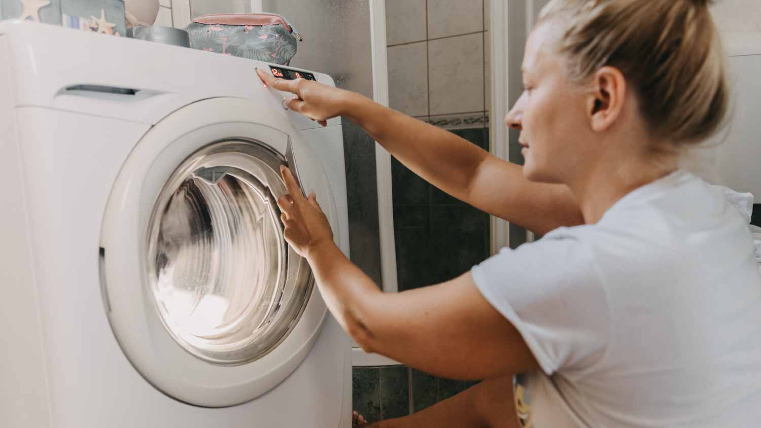 Woman choosing program on dryer machine