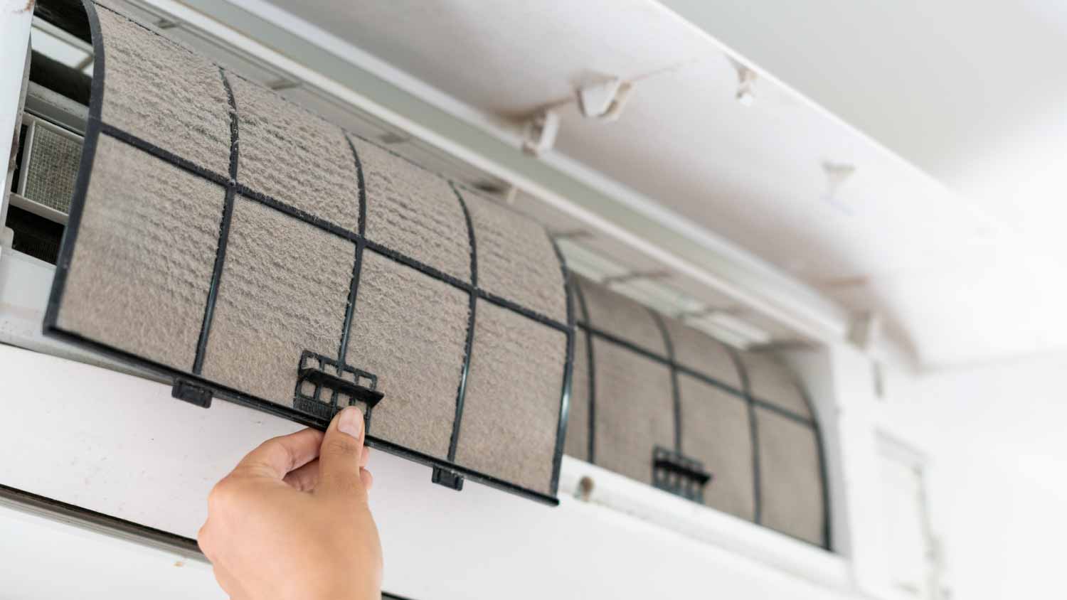 Woman cleaning the air conditioner filter