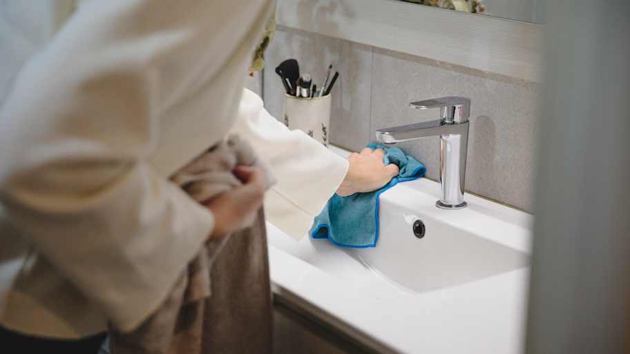 Woman cleaning bathroom sink